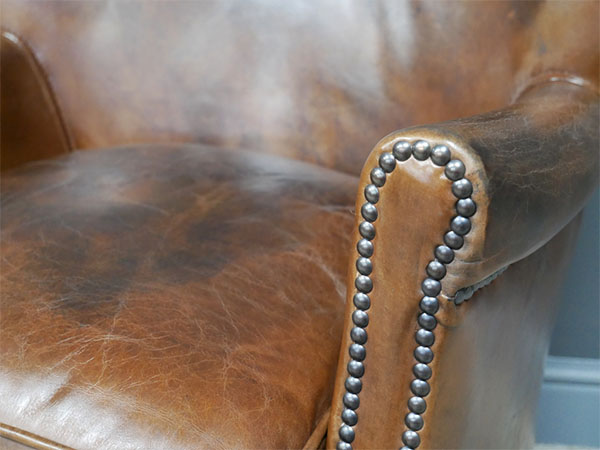 Brazilian Brown Leather Cosy Chair - Close up image showing the vintage brown leather finish & studded detailing