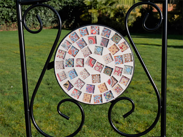 Close up image showing the mosaic pattern and swirl pattern on the inside back of the Mosaic glass / metal garden chair