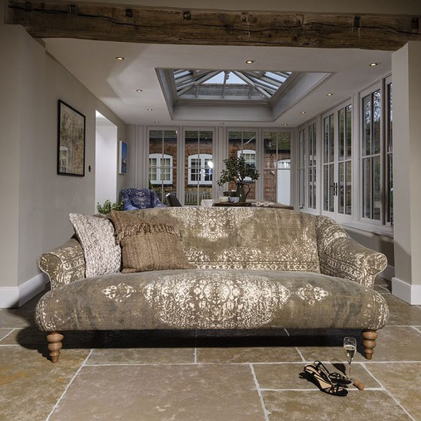 Tetrad Jacaranda Midi Sofa with a Jacaranda Chair in the background of the image